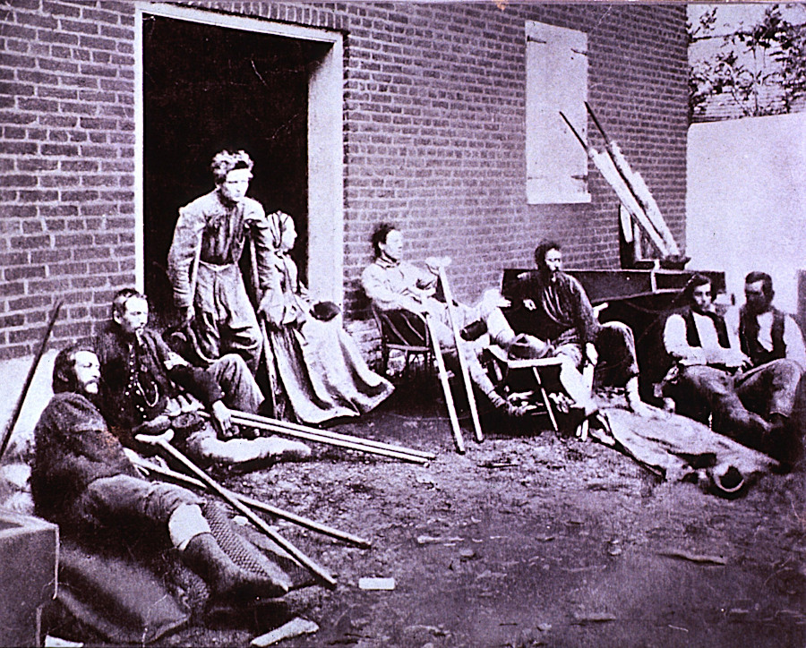 Historic photograph of wounded Civil War soldiers seated outside a hospital